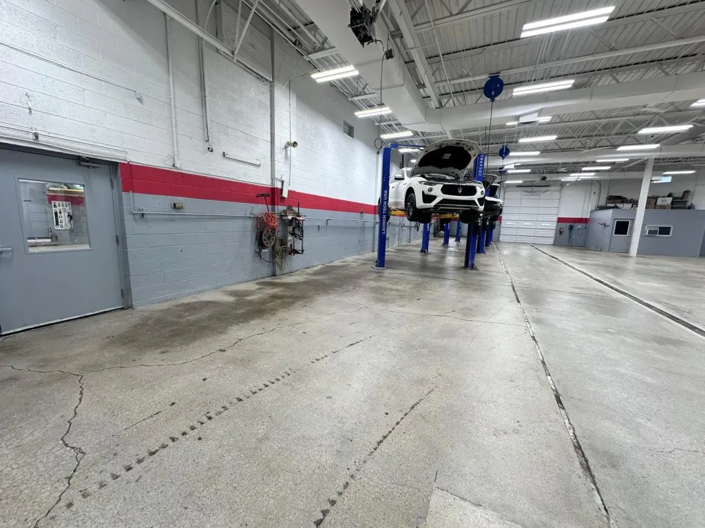 Professional operating a heavy grinding machine for concrete polishing in an industrial space